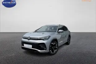 Volkswagen Tiguan gris en 3/4 avant droit avec jantes noires et calandre R-Line distinctive.