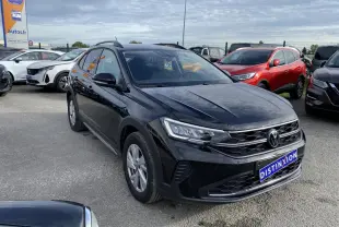 Volkswagen Taigo noir intense vu en 3/4 avant droit sur parking avec calandre et phares LED visibles.