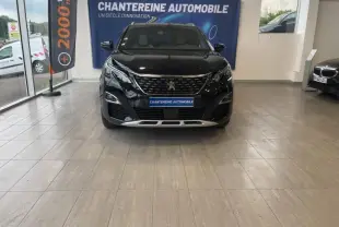 Peugeot 3008 Hybrid 225ch GT noir Perla Nera vue de face en showroom avec calandre chromée et logo lion visible.