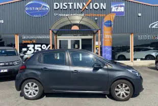 Profil droit d'une Peugeot 208 gris shark 2016 avec enjoliveurs 15 pouces, stationnée devant un concessionnaire multimarque Distinxion.