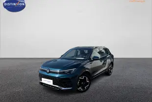 Volkswagen Tiguan 2025 bleu en 3/4 avant droit avec jantes alliage et toit ouvrant panoramique visible.