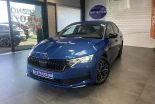 Skoda Octavia 2025 bleu foncé vue 3/4 avant en intérieur avec jantes alliage noires et calandre marquée Sportline.