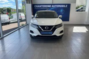 Vue frontale d'un Nissan Qashqai blanc lunaire 2019 exposé en showroom avec logo Nissan visible sur la calandre.