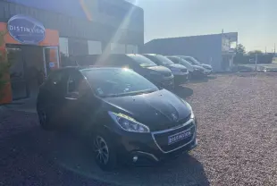 Peugeot 208 noire vue en 3/4 avant gauche sur un parking devant un bâtiment avec enseigne Distinxion.