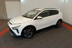 Hyundai Bayon blanc en 3/4 avant droit, avec jantes noires et toit ouvrant visible en intérieur fermé.