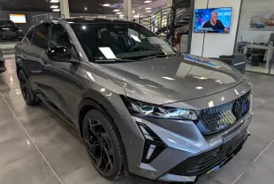 Vue 3/4 avant droit du Renault Rafale gris schiste avec calandre noire et jantes noires en showroom.
