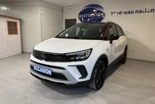Opel Crossland blanc 2021 en 3/4 avant droit, toit noir et jantes noires dans un showroom intérieur.