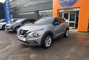 Nissan Juke gris perle métallisé vu en 3/4 avant droit devant un concessionnaire Distinxion.