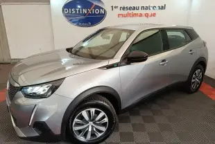 Peugeot E-2008 électrique gris clair en 3/4 avant droit, avec jantes spécifiques et rétroviseurs noirs brillants.