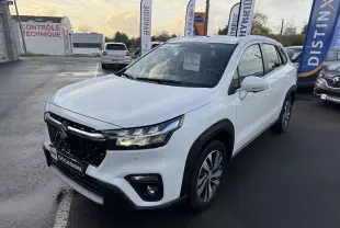 Suzuki S-Cross blanc 2023 en 3/4 avant droit, avec calandre noire et phares LED allumés sur parking.