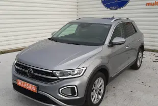 Volkswagen T-Roc gris pyrite en 3/4 avant droit, SUV compact avec phares LED et jantes alliage visibles.