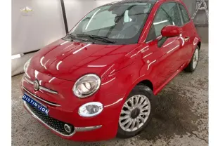 Vue 3/4 avant droite d'une Fiat 500 Dolcevita rouge brillante avec jantes spécifiques et badge distinctif sur aile avant.