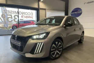 Peugeot 208 gris clair en 3/4 avant droit avec feux LED et jantes tôle 16 pouces en showroom.