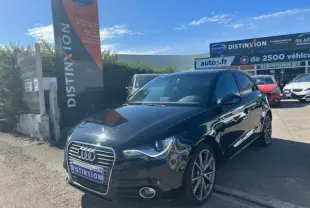 Audi A1 Sportback noir vue 3/4 avant droit, finition Ambition Luxe S, garée devant un concessionnaire Distinxion.