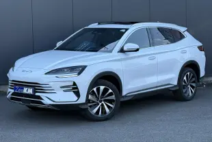 Vue 3/4 avant droite du SUV BYD SEAL U blanc Snow White avec jantes alliage bicolores et barres de toit en aluminium.