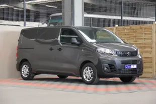 Peugeot Expert Fourgon gris en 3/4 avant droit, avec boucliers noirs et roues tôle 16 pouces à cabochons noirs.