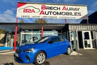 Opel Corsa 1.2 Turbo Elegance bleu voltaïque en 3/4 avant droit devant un garage Brech Auray Automobiles.