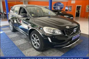 Volvo XC60 noir vue 3/4 avant droit en intérieur, avec calandre distinctive et jantes alliage visibles.
