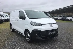 Vue 3/4 avant d’un FIAT Scudo Fourgon blanc 2024 avec pare-chocs noir et jantes acier, sur parking extérieur.