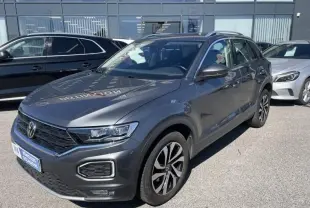 Volkswagen T-Roc gris foncé métal vu de 3/4 avant droit, avec jantes alliage et calandre noire distinctive.
