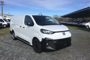 Fiat Scudo Fourgon blanc en 3/4 avant droit, avec pare-chocs noirs et garde au sol réhaussée visible sur terrain gravillonné.