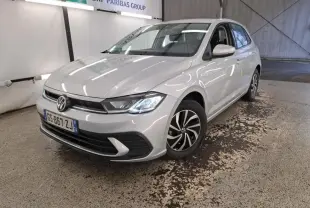 Volkswagen Polo gris clair vue 3/4 avant droit, phares LED allumés et jantes alliage distinctives.