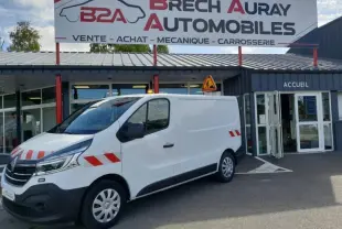 Renault Trafic Fourgon blanc glacier vu en 3/4 avant droit, équipé de bandes réfléchissantes rouges sur la carrosserie.