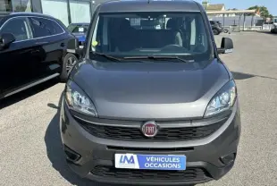 Vue frontale d'un FIAT Doblo Cargo gris foncé avec calandre noire et plaque "Véhicules Occasions" visible.