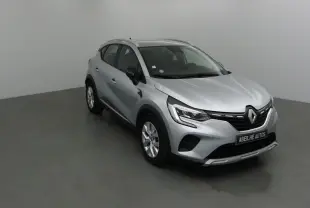 Renault Captur gris Highland en 3/4 avant droit, mettant en valeur ses optiques LED et sa calandre noire distinctive.
