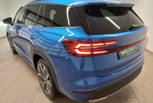 Vue 3/4 arrière droite du Skoda Kodiaq 2024 bleu RS avec feux LED allumés et jantes alliage 20 pouces anthracite.