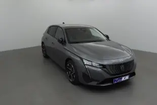 Peugeot 308 gris Sellenium vue 3/4 avant droit, avec calandre noire et phares LED distinctifs.