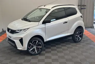 Aixam Ambition 0.5 Crossover Premium blanc, vue 3/4 avant droit, avec rétroviseur caméra côté gauche visible.