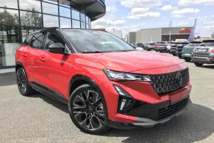 Renault Austral rouge et noir en 3/4 avant droit, avec jantes alliage noires et calandre imposante noire.