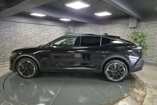 Profil côté gauche d'une Peugeot 408 électrique 2024 noire Perla Nera avec jantes alliage 19 pouces diamantées.