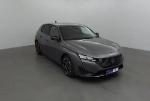 Peugeot 308 gris Sellenium vue 3/4 avant droit, avec calandre noire et jantes alliage distinctives.