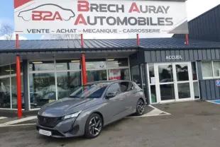 Peugeot 308 gris Sélénium vue 3/4 avant droite devant un garage Brech Auray Automobiles.