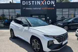 Hyundai Tucson IV blanc polaire toit noir vu en 3/4 avant droit avec calandre N-Line et jantes distinctives.