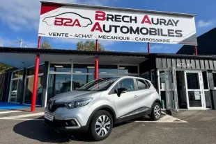 Renault Captur gris platine vu en 3/4 avant droit devant un garage Brech Auray Automobiles.