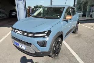 Dacia Spring 65 Extreme bleu ardoise en 3/4 avant droit, avec rétroviseurs bronze et jantes noires brillantes.