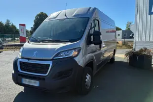 Peugeot Boxer cabine approfondie gris, vue 3/4 avant droit, avec calandre noire et pare-chocs foncé visible.