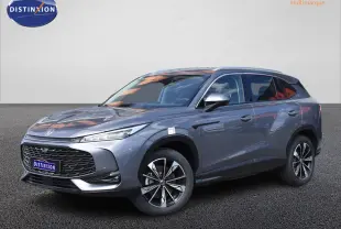 MG Motor EHS gris en 3/4 avant droit, avec jantes alliage noires et phares LED fins, sur fond neutre.