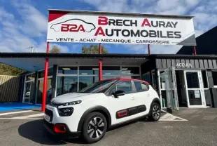 Citroën C3 1.2 83ch Shine vue 3/4 avant droit en blanc Banquise avec toit et détails rouges devant concession Brech Auray Automobiles