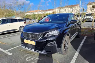 Peugeot 3008 noir vue 3/4 avant droit, avec calandre chromée et jantes alliage bicolores, stationnée devant un mur blanc.