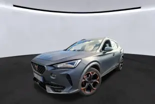 SUV CUPRA Formentor gris foncé mat en 3/4 avant droit, avec jantes noires et détails cuivrés, dans un showroom intérieur.
