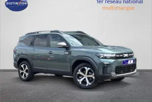 Vue 3/4 avant droite du Dacia Bigster gris avec barres de toit et jantes alliage distinctives.