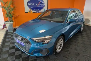 Audi A3 Sportback bleu Atollblau en 3/4 avant droit, avec calandre hexagonale et jantes alliage 17 pouces visibles.