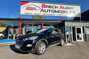 Hyundai Tucson Phantom Black 2019 en 3/4 avant droit devant un garage avec enseigne Brech Auray Automobiles.