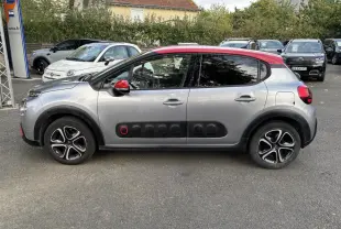Profil côté gauche d'une Citroën C3 gris clair avec toit rouge et Airbump noir à détail rouge sur porte avant.