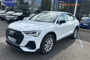 Audi Q3 Sportback blanc en 3/4 avant droit, avec calandre noire et feux LED distinctifs visibles.