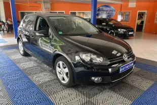 Volkswagen Golf VI noire vue en 3/4 avant droit dans un showroom avec sol à motifs bleus et gris.